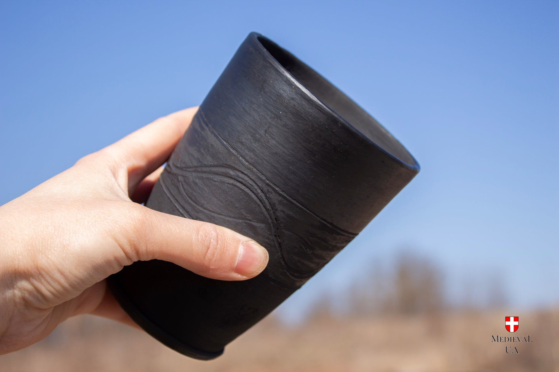 Black ceramic LARP goblet shown next to a hand for scale