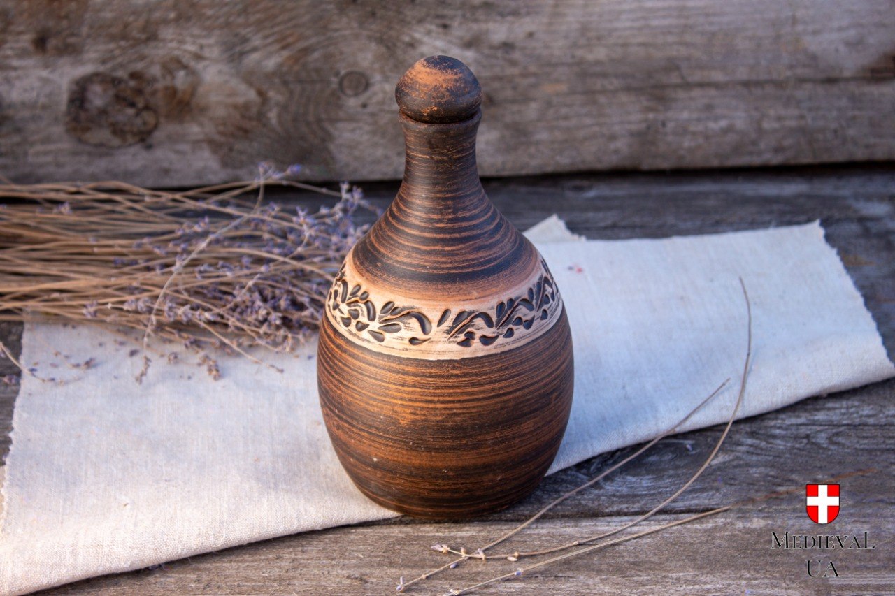 Milk-fired clay mead bottle with hand-carved leaf band, standing