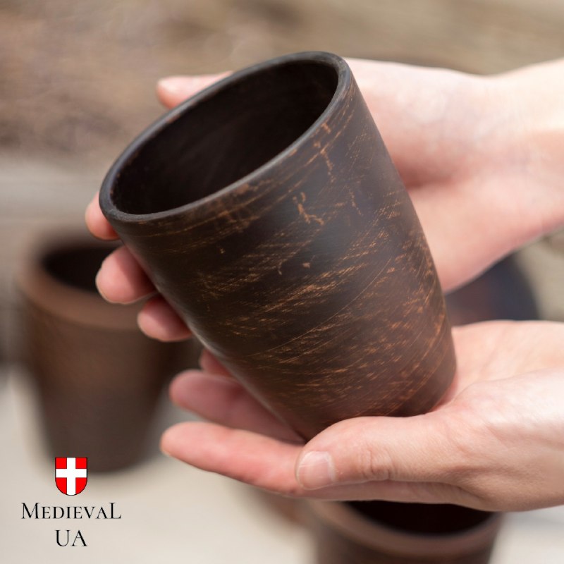 Hands cradling a 300 ml handmade clay cup, showing its size and matte milk fired surface