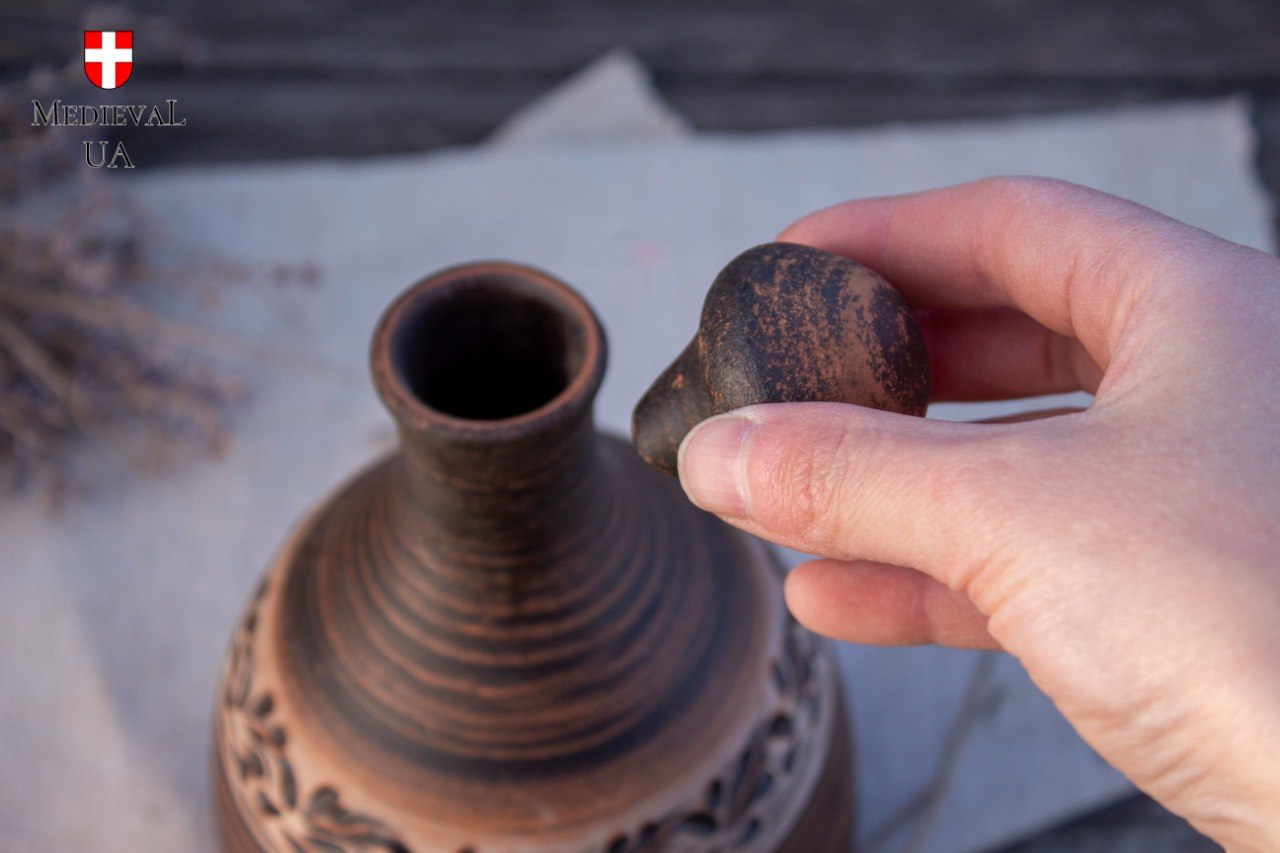 Round ceramic stopper lifted from the neck of a clay mead bottle
