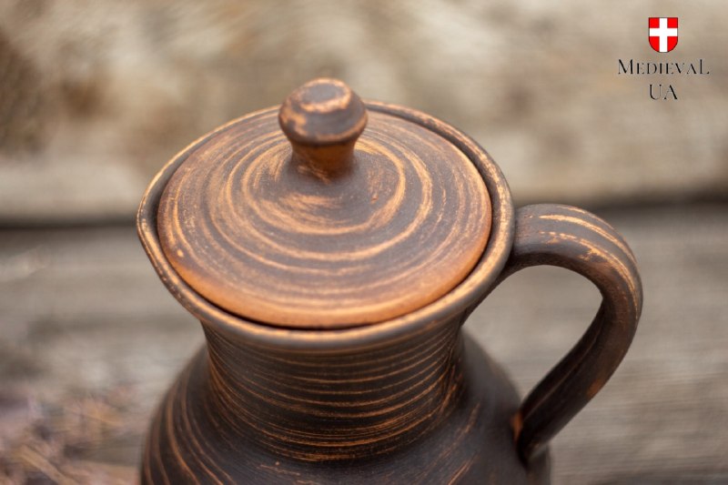 Close-up of the turned clay lid and pinch finial seated on the pitcher's neck
