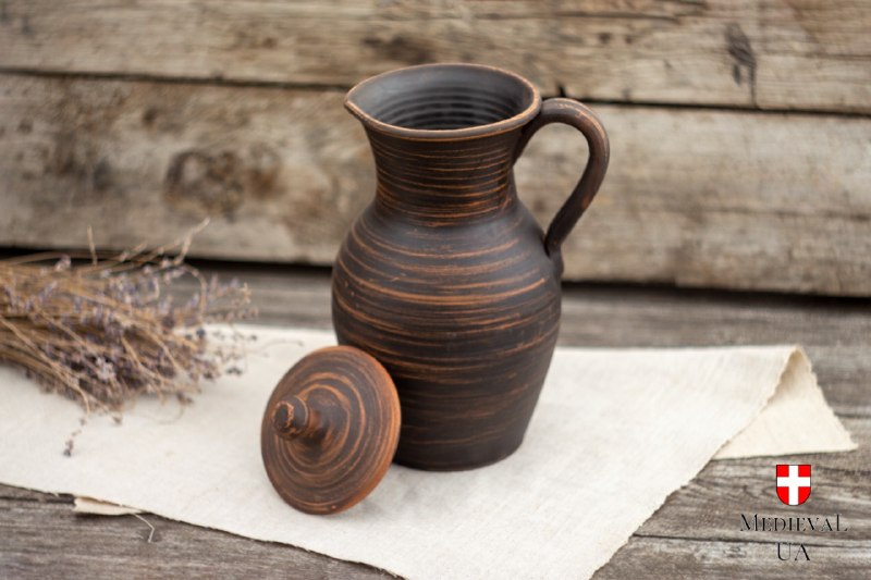Handmade clay pitcher with its lid removed, revealing the wide pouring neck