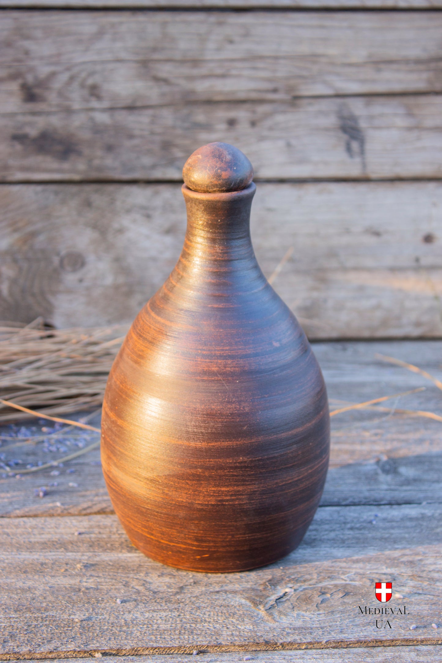 Handmade clay wine bottle in unglazed red clay with round stopper