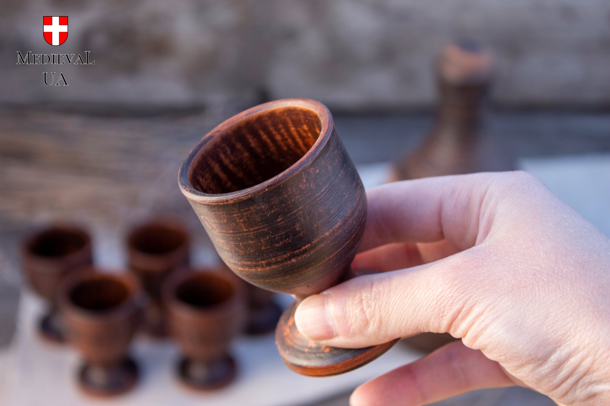 Rounded bowl of a footed clay liqueur cup, unglazed red clay