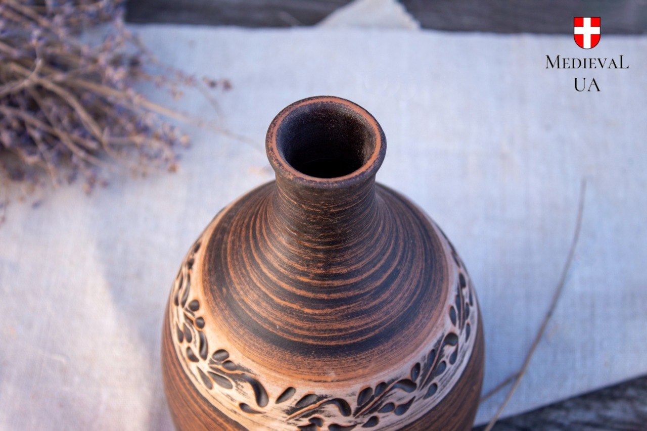 Top view of a narrow mead bottle neck above a carved clay shoulder