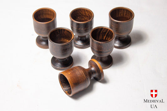 medieval ceramic liqueur cups showing milk-fired markings, one on its side