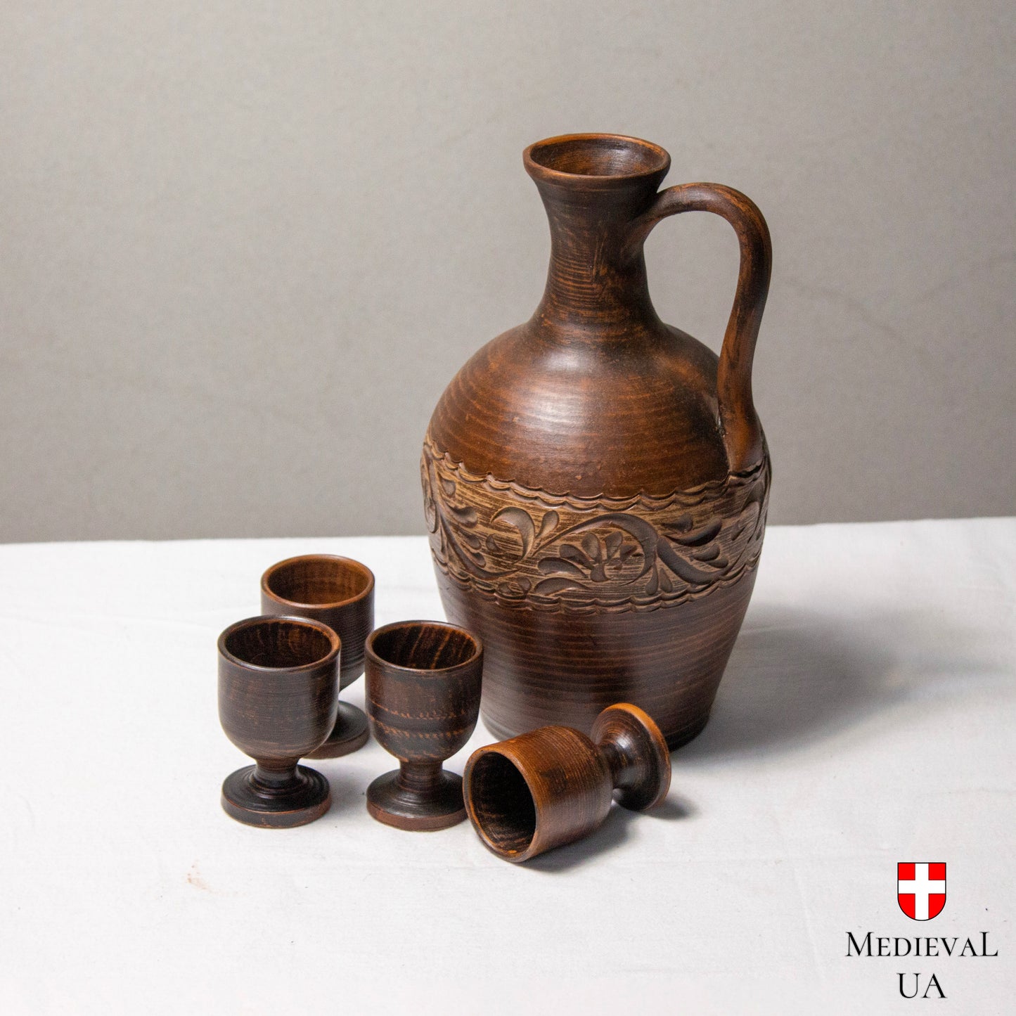 Hand-carved floral band on a rustic clay wine jug, close view