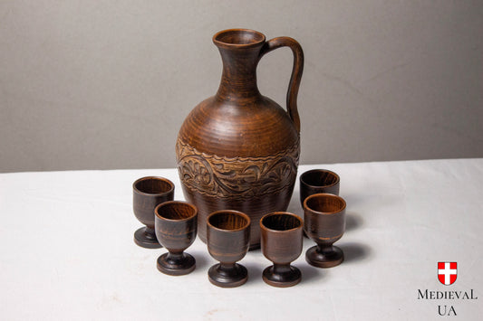 Medieval wine jug set with carved clay jug and six footed cups