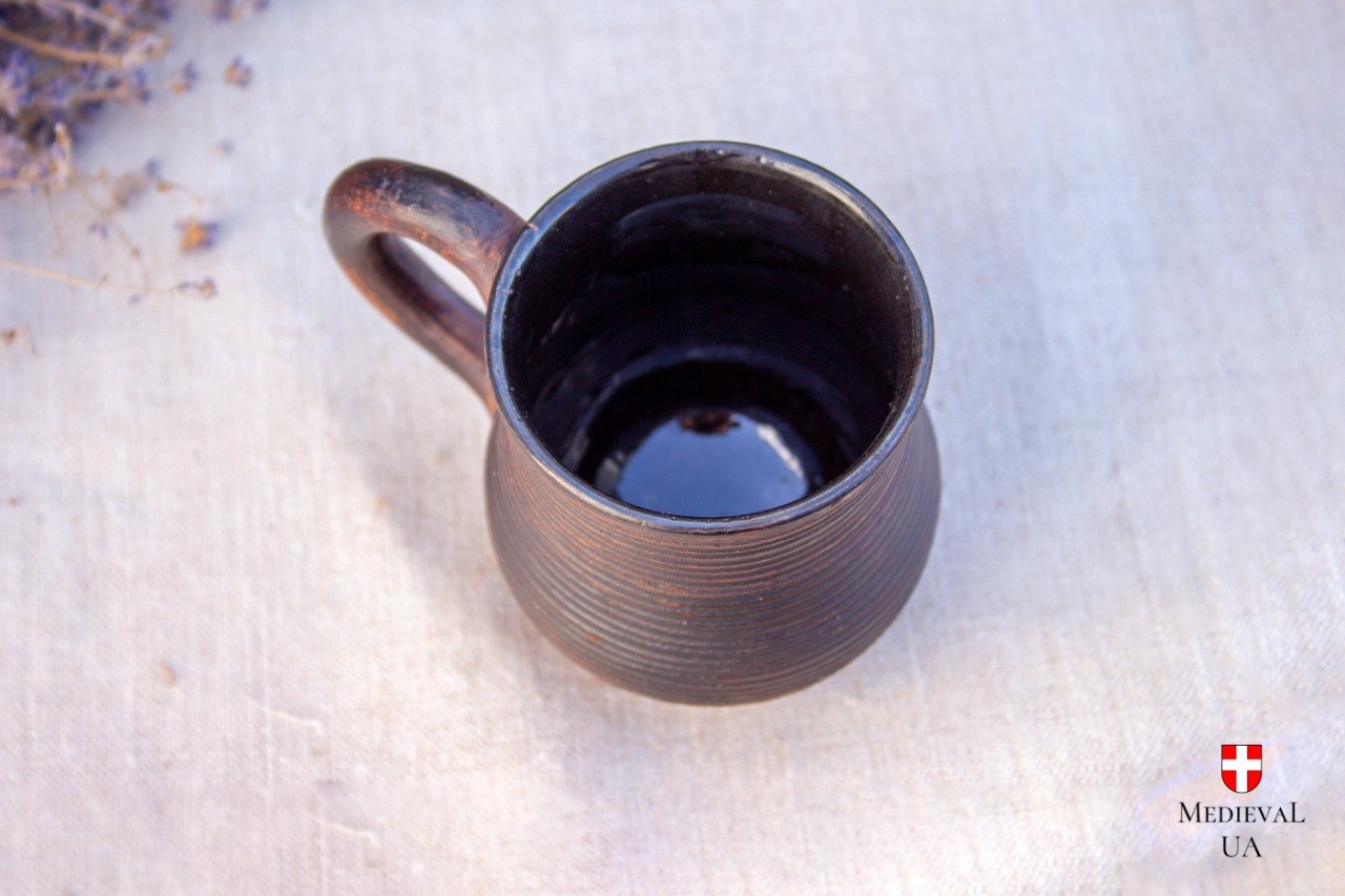 Top view of the small ribbed clay mug showing the glossy black food-safe glazed interior
