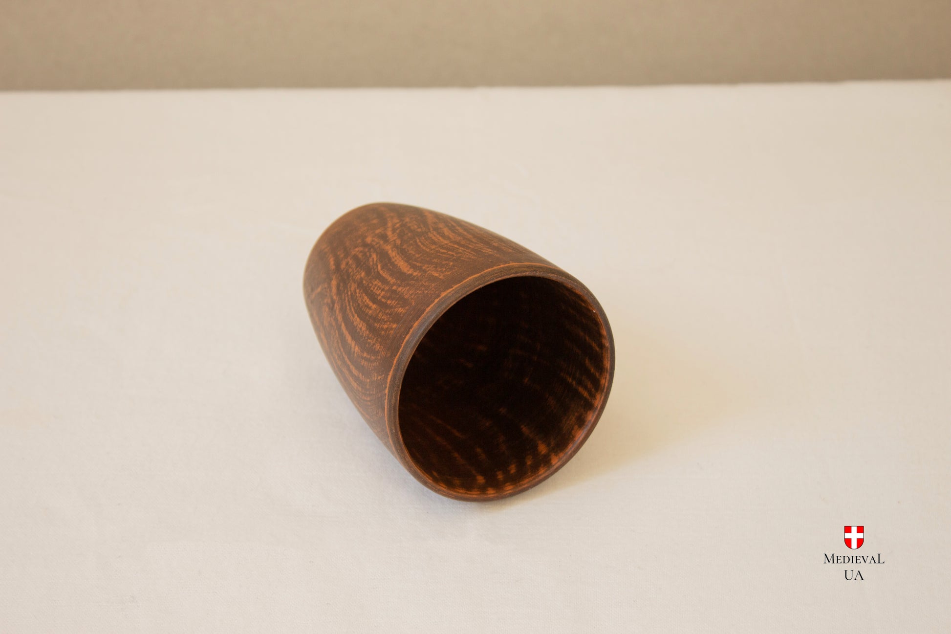 Close-up of the textured wood-like surface of the clay cup