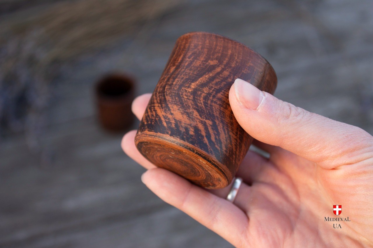 Amber and dark brown milk-fired shot cup seen from the side